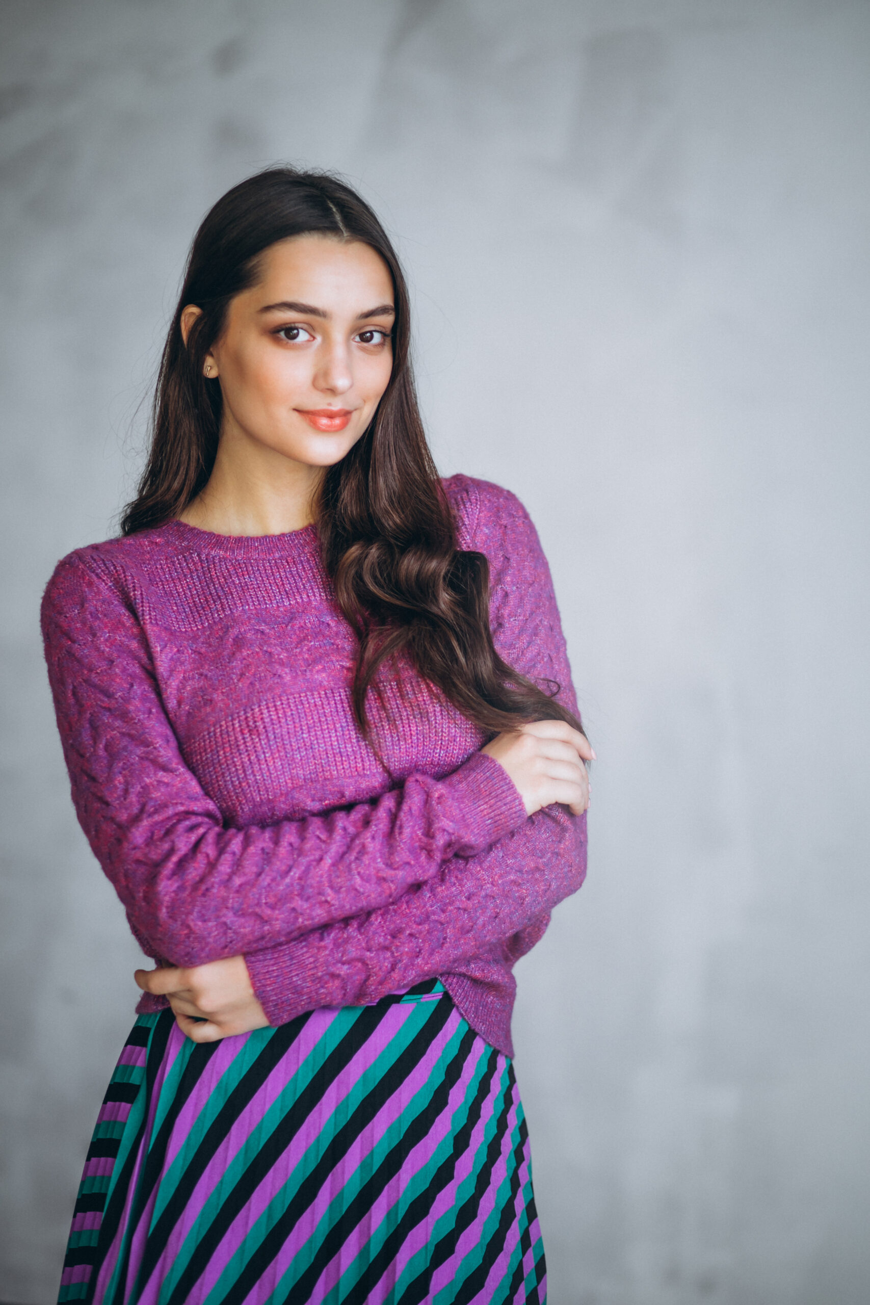 beautiful woman in a purple sweater and skirt in studio