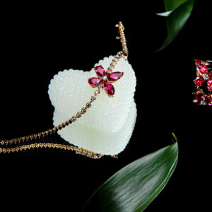 side view of jewellery set of golden bracelet and rind with diamonds and rubies in a shape of butterfly