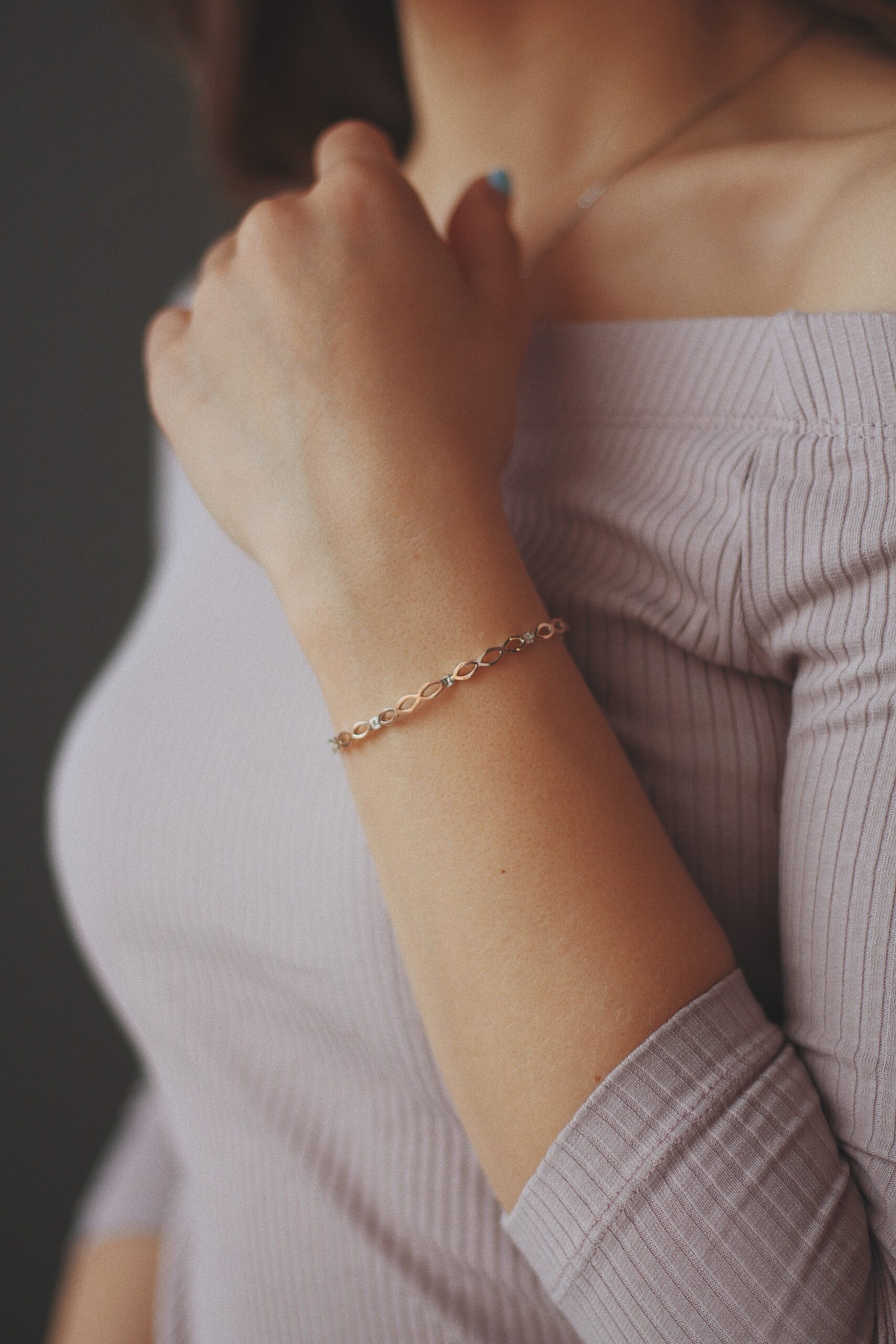 vertical closeup shot of a female wearing a golden bracelet